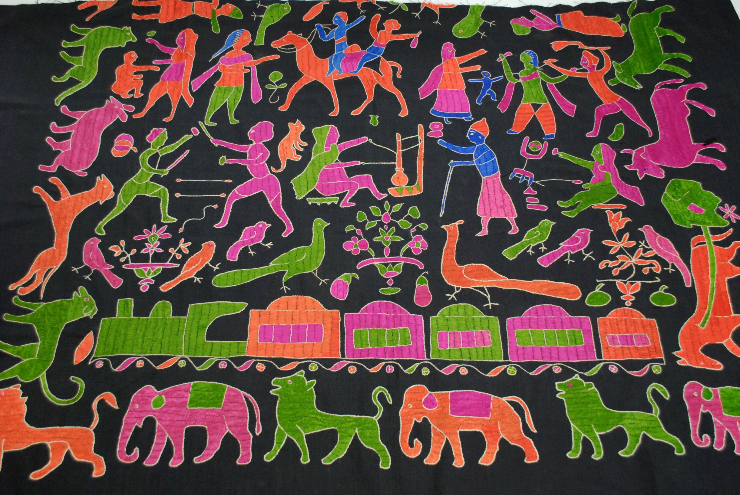 orange, blue, pink and green embroidered animals and people on a black cloth background