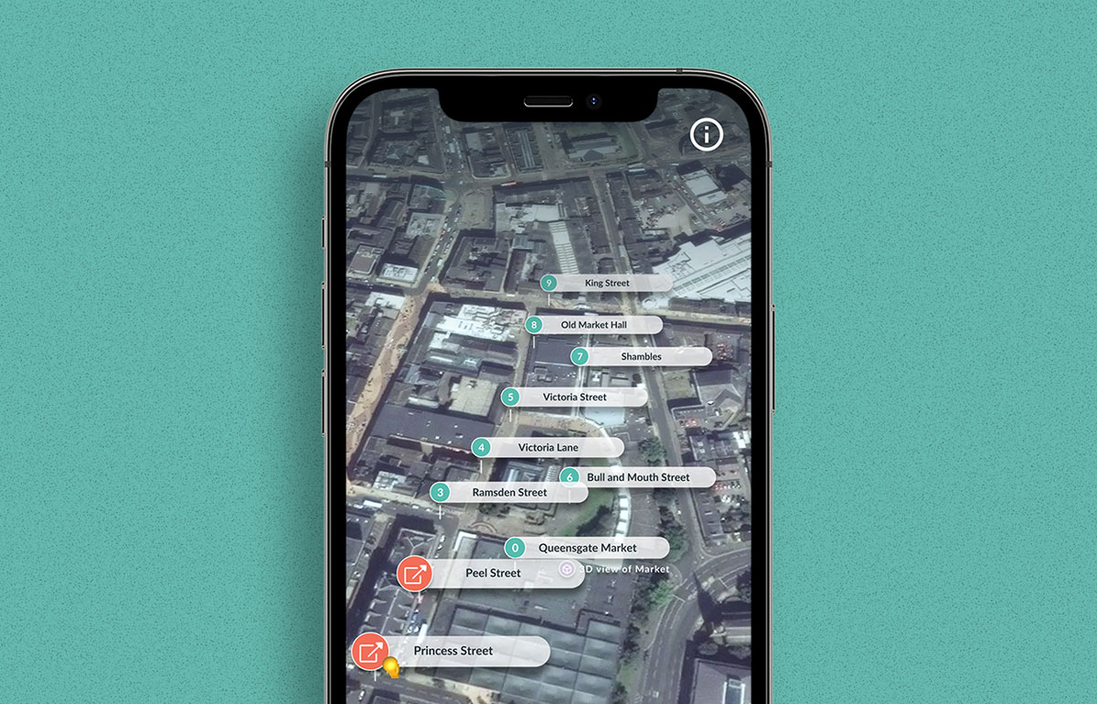 Iphone screen with an aerial view of a town centre and tagged locations in green and red