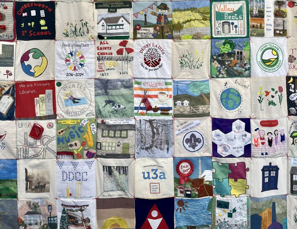 A close up of multiple squares from a community quilt
