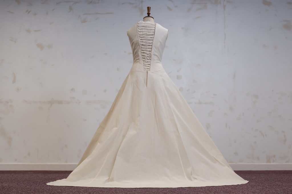 A floor length calico dress with a corseted back displayed on a dressmaker's mannequin