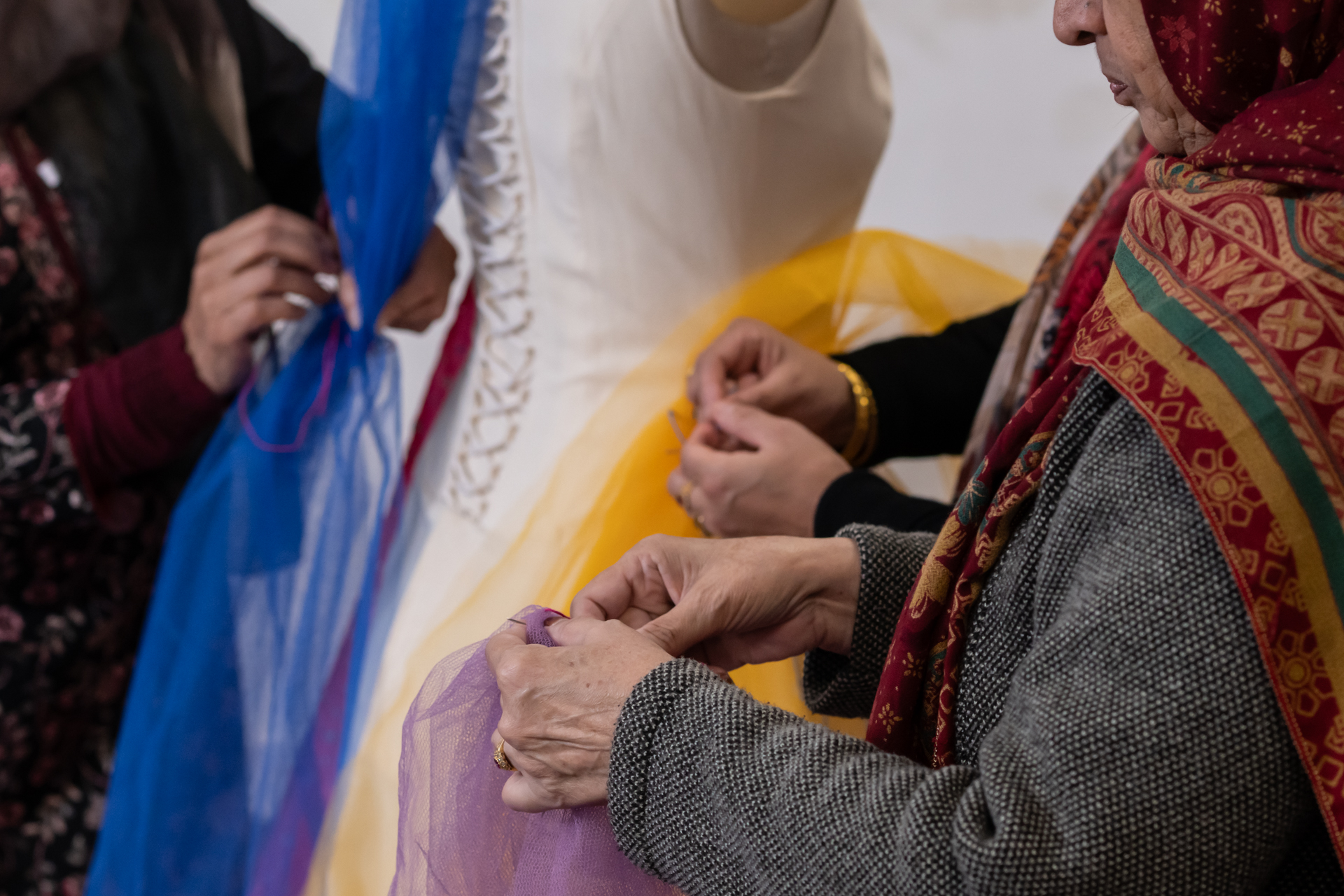Close up of hands pinning fabric to a mannequin