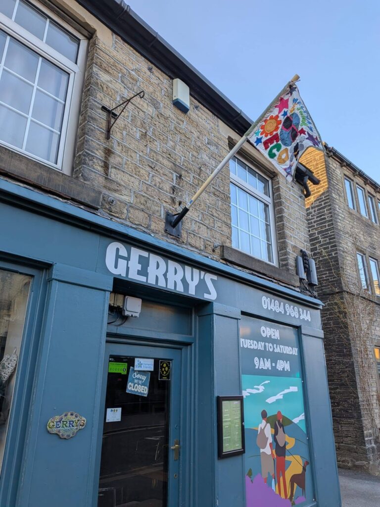 A flag on a pole above an ice cream shop