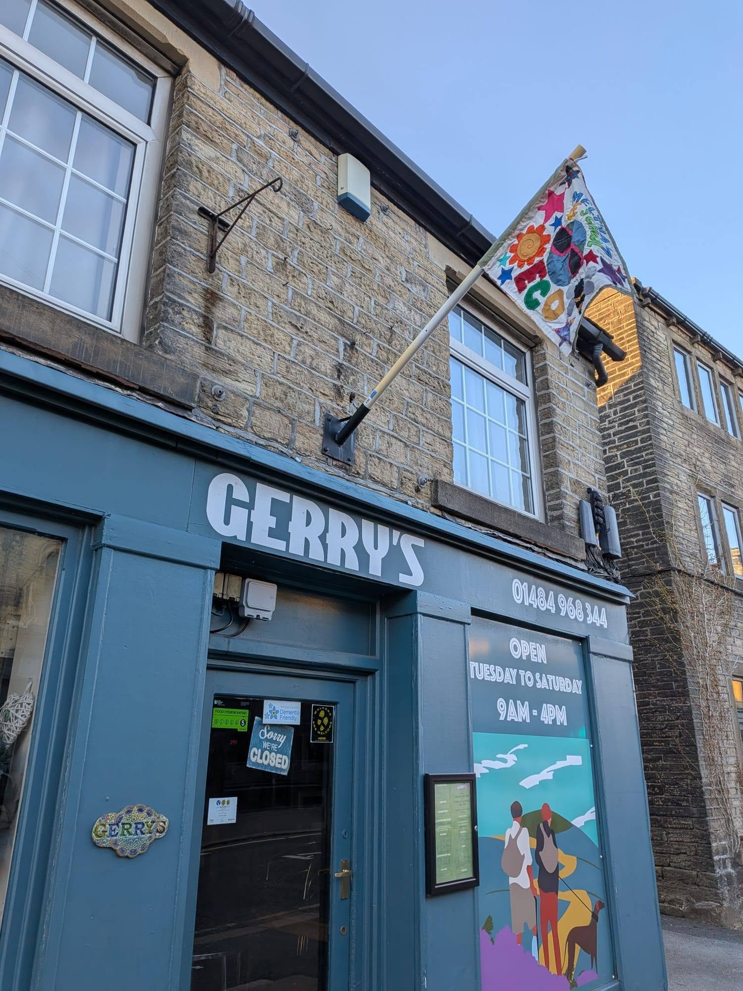 A flag on a pole above an ice cream shop